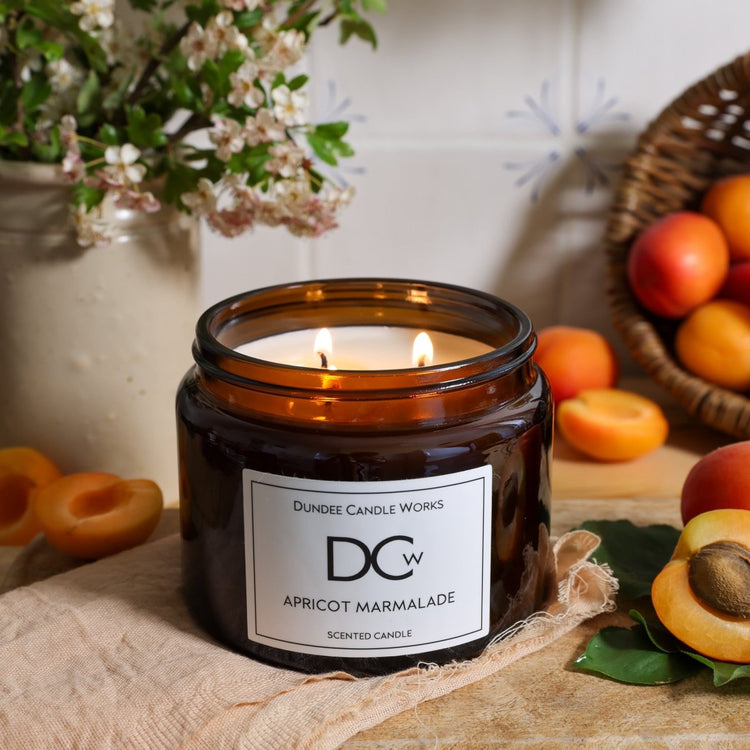 Triple Wick coconut wax Apricot Marmalade Candle surrounded by apricots and flowers