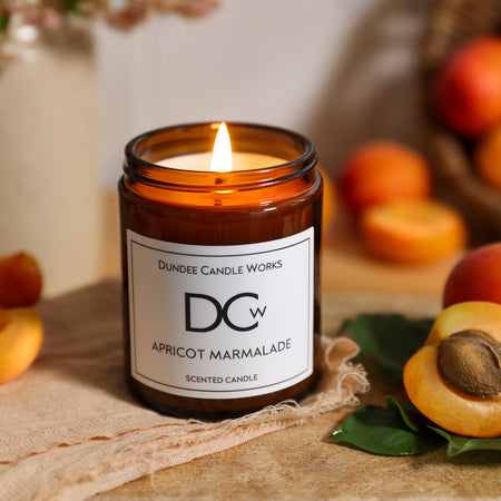 180ml Apricot Marmalade Candle surrounded by apricots and flowers.
