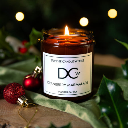 Single wick Dundee Candle Works Cranberry Marmalade candle on a festive decorative background