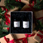 A Cranberry Marmalade candle and Marmalade Gingerbread Diffuser in a white gift box surrounded by Christmas wrapping paper and holly leaves.