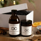 Dundee Candle Works Marmalade Gingerbread candle and diffuser in front of white gift box on a wooden surface with decorative elements.