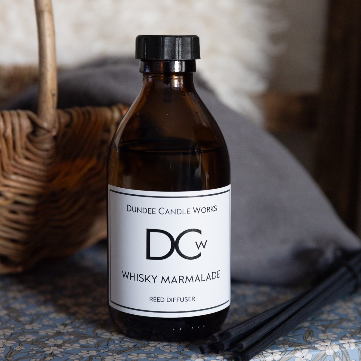 Dundee Candle Works large Whisky Marmalade Diffuser beside a wicker basket.